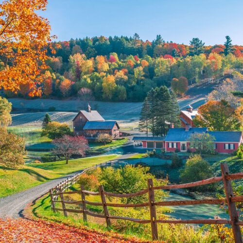 An early autumn foliage scene of houses in Woodstock, Vermont mountains